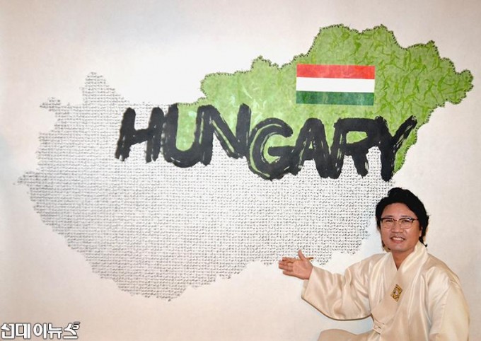 한한국 세계평화작가가 38번째 국가, 헝가리 평화지도을 완성하고 작품설명을 하고 있다(사진=세계평화사랑연맹 제공).JPG