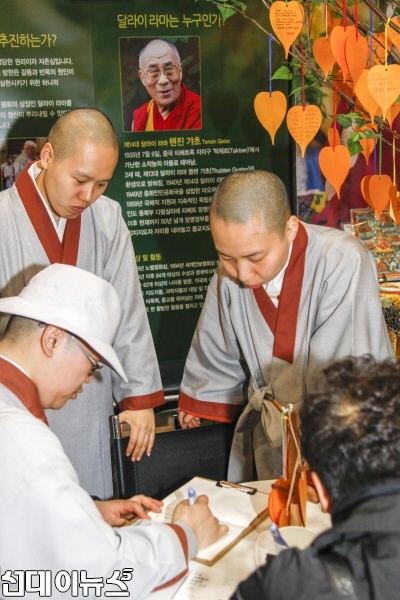지난 24일 서울무역전시컨벤션센터(SETEC)에서 개막된 2016 서울국제불교박람회에 마련된 달라이라마 방한 서명운동 부스에 학승들이 참여 서명하고 있다.