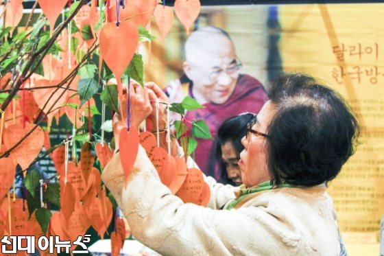 지난 24일 서울무역전시컨벤션센터(SETEC)에서 개막된 2016 서울국제불교박람회에 마련된 달라이라마 방한 서명운동 부스에 불자들이 참여 서명하여 희망나무에 메달고 있다.